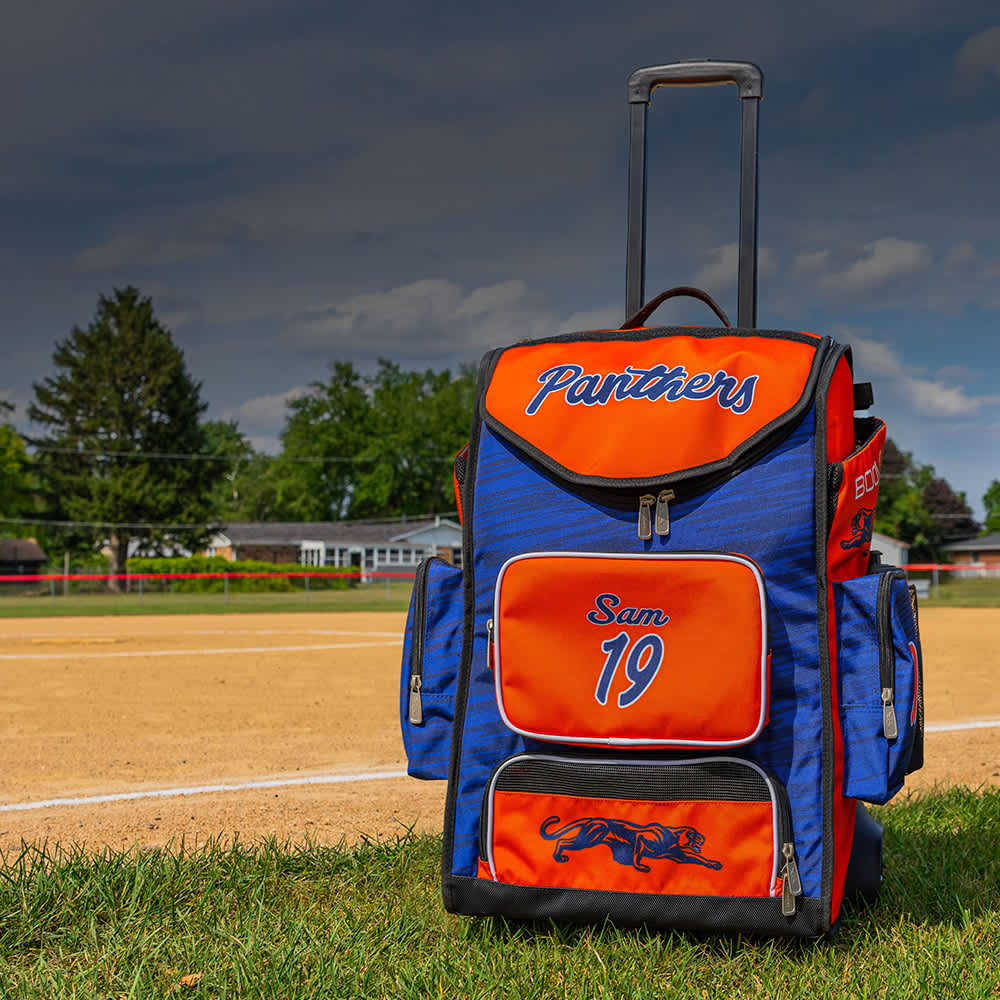 A blue and orange custom bat bag filled with softball gear