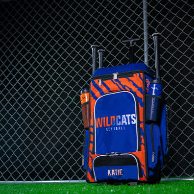 A blue and orange custom bat bag filled with softball gear