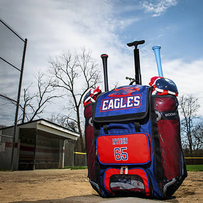 A blue and red custom bat bag filled with baseball gear