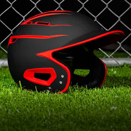 A black and red batting helmet on the ground