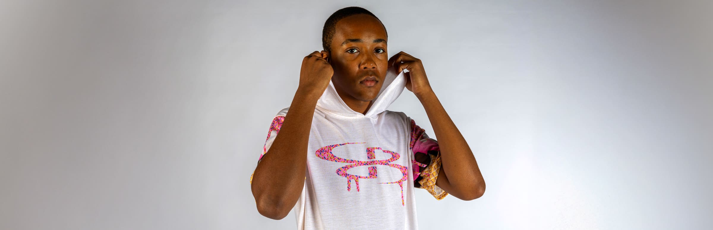 Boy in a pink and white ice cream graphic short sleeve hoodie