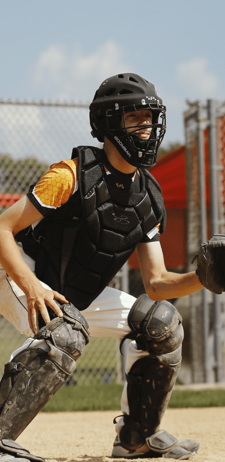 A baseball player in black catcher's gear